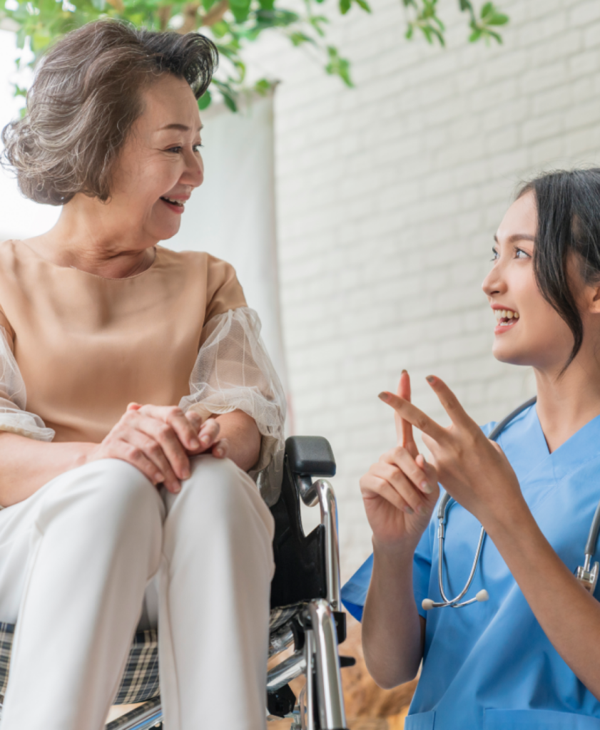 a nurse talking to an elderly woman in a wheelchair.