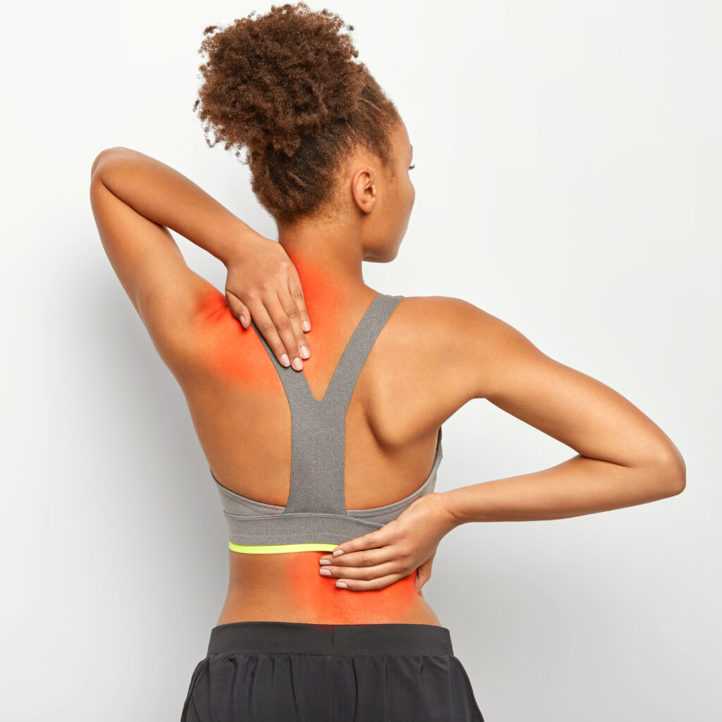 A woman with highlighted back pain areas holds her upper and lower back.