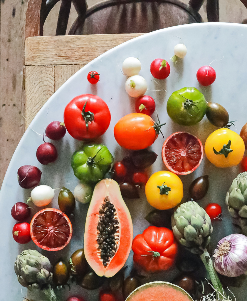 a plate of fruits and vegetables on a table.