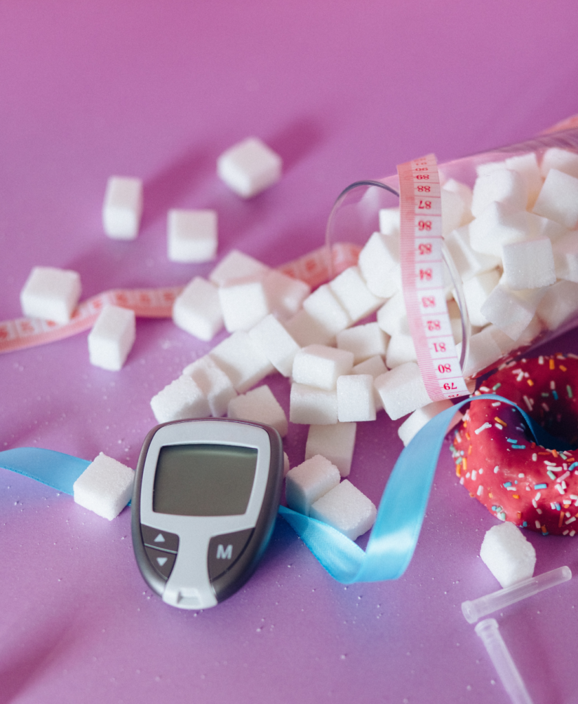 sugar, donuts and a glucose meter on a pink background.
