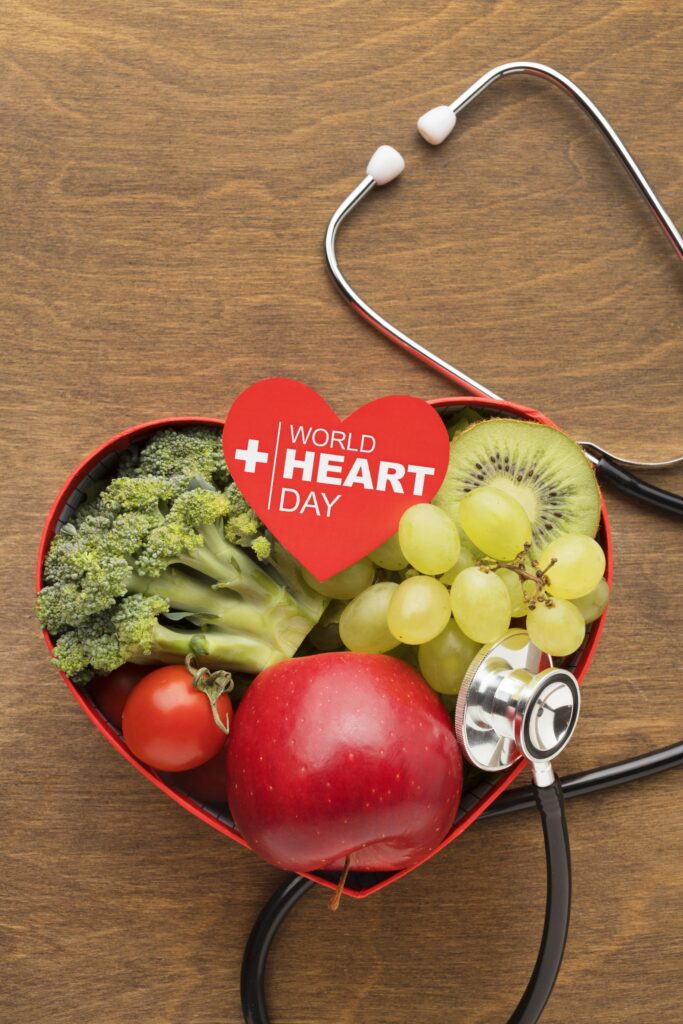 A heart shaped box with fruits and vegetables and a stethoscope.